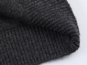 Detailed macro view of dark grey knit cardigan with textured ribbing and soft wool texture