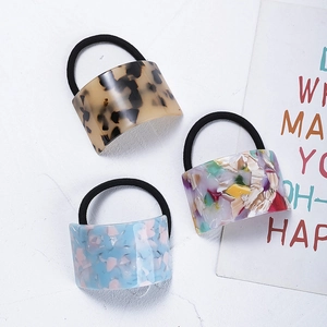 Close-up of acetic acid hair ties with geometric patterns in amber and light blue hues