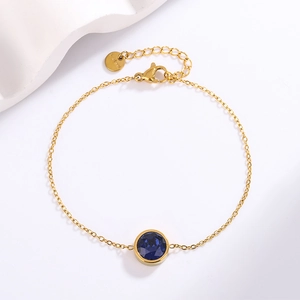 Detailed close-up of a 18k gold plated stainless steel bracelet with a blue zircon crystal