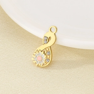 Macro view of 18K gold infinity pendant with enamel daisy flower and sparkling crystals