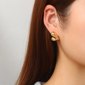 Boucles d'oreilles cœur en acier inoxydable doré 18K portées par un mannequin