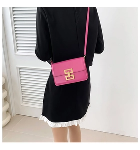 Detail view of pink crossbody bag with golden H-clasp and high-quality synthetic leather