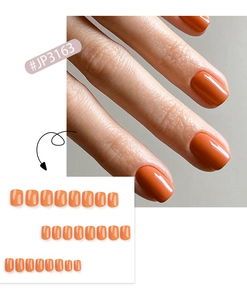 Detail view of glossy orange-red press-on nails set with 24 pieces square shape style