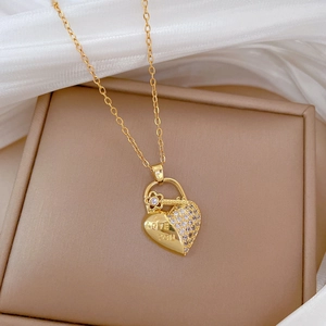 Detailed macro view of a gold heart necklace with floral accents and LOVE YOU engraving