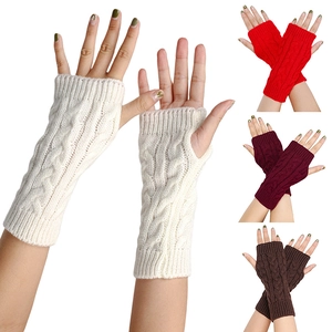 Detail of cable knit fingerless gloves showing textures in cream, red, burgundy and brown