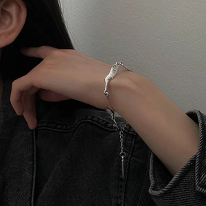 Dettaglio del bracciale argento irregolare con trama in metallo liquido al polso