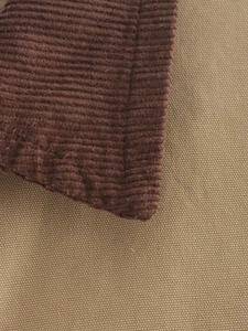Detail of brown corduroy and light khaki twill patchwork fabric with neat stitching