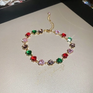 Macro detail of heart-shaped multi-color crystal bracelet with gold-tone prong settings