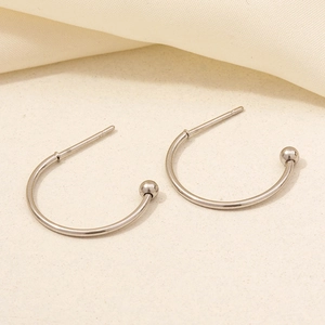Detailed macro view of silver 304 stainless steel minimalist C-shaped hoop earrings