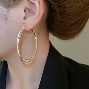 Fashionable gold interlaced hoop earrings for women with sparkling pavé crystal detail