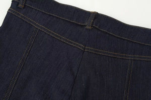 Détail du jean bleu foncé montrant les coutures contrastées à la taille et à l'empiècement