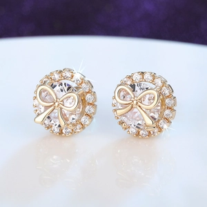 Macro shot of gold bow stud earrings with sparkling cubic zirconia halo and large main stone