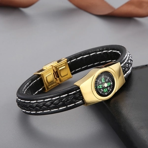 Detailed macro view of woven leather bracelet with integrated compass and gold clasp