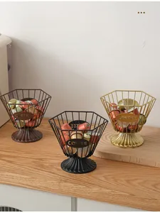 Three metal coffee pod baskets in bronze, matte black, and gold colors with coffee tags