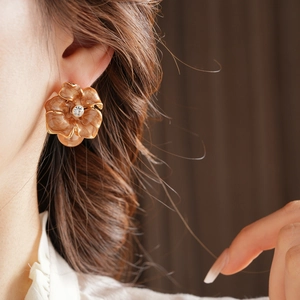 Gros plan de boucles d'oreilles fleur vintage avec émail marbre et perle pendante