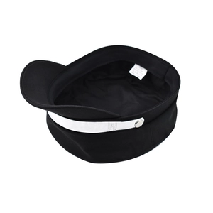 Detailed macro view of black newsboy hat featuring a silver metal band and 'M' logo
