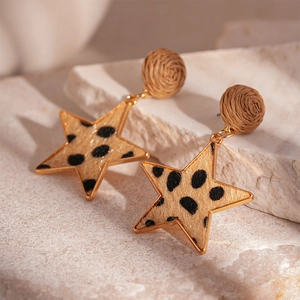 Macro shot of leopard print star earrings with woven circular studs and gold edges