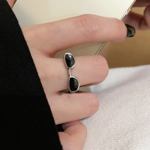 Gros plan sur une bague Y2K argentée en forme de lunettes avec émail noir