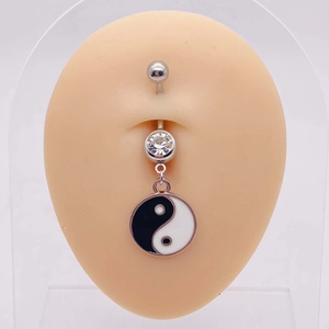 Detail of silver belly ring with black and white yin yang pendant and clear zircon stone
