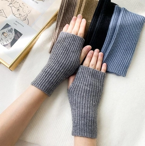 Detailed texture of rib-knitted fingerless gloves in grey, coffee, black, and misty blue