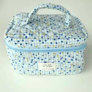 Detail of blue and white checkered quilted cotton makeup bag with yellow polka dots