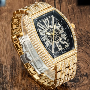 Macro shot of gold tonneau case watch with diamonds and black compass dial