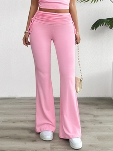 Détail du pantalon évasé à taille haute avec fronces latérales et cordons décoratifs
