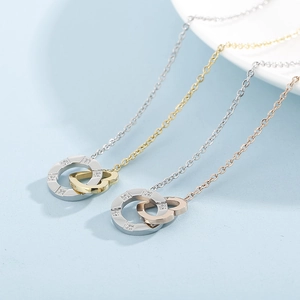 Detail of interlocking heart rings necklace with cubic zirconia in silver and gold plating