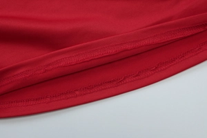 Détail de la texture du tricot rouge avec couture de qualité à double aiguille sur le bord