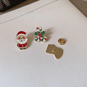 Detail of Santa and candy cane enamel brooches with butterfly clutches and gold plating