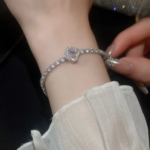 Close-up of silver-tone clover pearl bracelet with cubic zirconia on a model's wrist