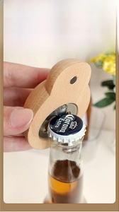 Macro detail of wooden bottle opener lifting a cap showing stainless steel fixture