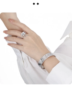 Detail of S925 sterling silver flower ring and hammered metal cuff on a model