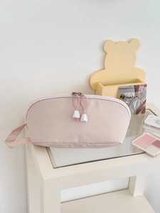 Detail of light pink large capacity cosmetic bag with dual zippers and side handle strap