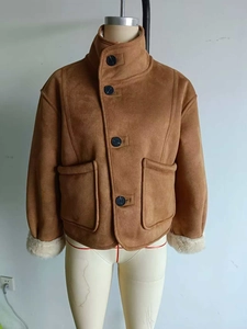 Detail view of brown suede jacket with white faux fur collar and large black buttons