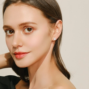 Elegant S925 silver cross stud earrings with blue opal stones on a female model