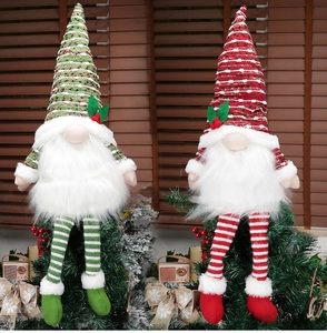 Detail of red and green Christmas gnomes with knit hats and long legs on wooden background