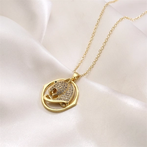 Close-up of gold leopard pendant with micro-pave cubic zirconia on white silk