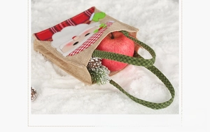 Rear view of Christmas burlap gift bag with green plaid handle and festive textures