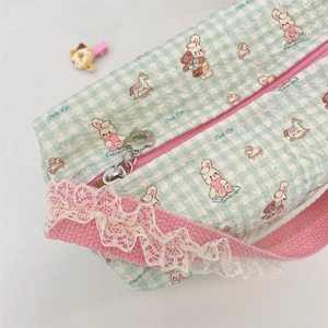 Detail of cute mint green checkered canvas bag with cartoon prints and lace trim decoration