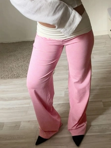 Detail of pink and white striped wide-leg pants with wide white fold-over waistband