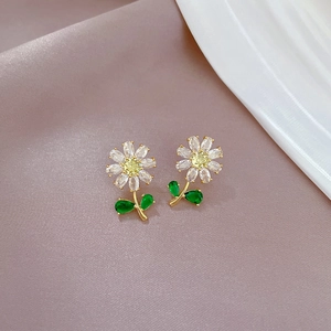 Close-up of titanium steel daisy stud earrings on purple velvet background