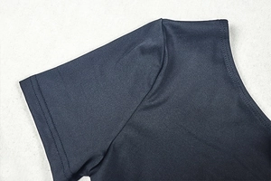 Gros plan détaillé sur l'ourlet de manche à double couture et l'épaule de robe noire