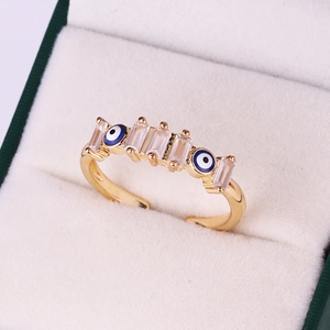 Macro shot of gold-plated evil eye ring with blue zircon stones in white jewelry box