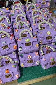 Detail of purple mini silicone bags with pearl handles and colorful cartoon charms