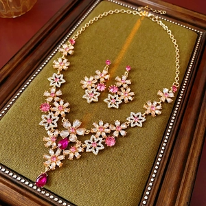 Detail of vintage flower jewelry set with pink crystals on green velvet tray