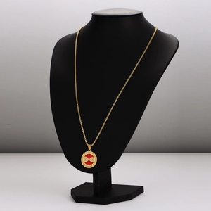 Golden stainless steel necklace with red zircon evil eye pendant on a black bust mannequin