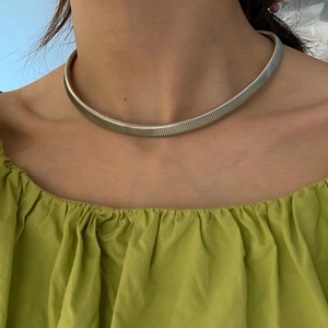 Close-up of a minimalist silver snake chain choker necklace worn on a model's neck