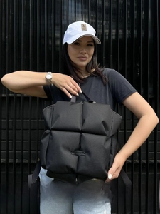 Détail du sac à dos matelassé noir avec motif carré doux et sangles en tissu