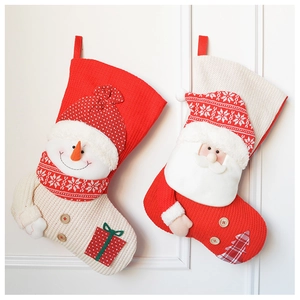Detail of knitted Christmas stockings with 3D snowman and Santa Claus hanging on wall